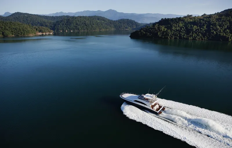Mare Blu Yacht Photos Pics Luxury Pro Boat Yachts Power Cat 80 cruising on serene lake, surrounded by lush green hills.