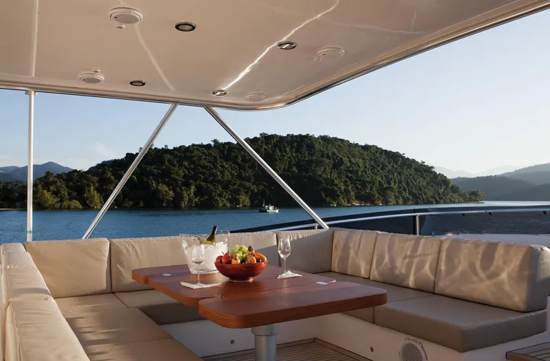 Mare Blu Yacht Photos Pics Luxurious seating area on 2008 Pro Boat Yachts Power Cat 80, overlooking serene waters and lush hills.
