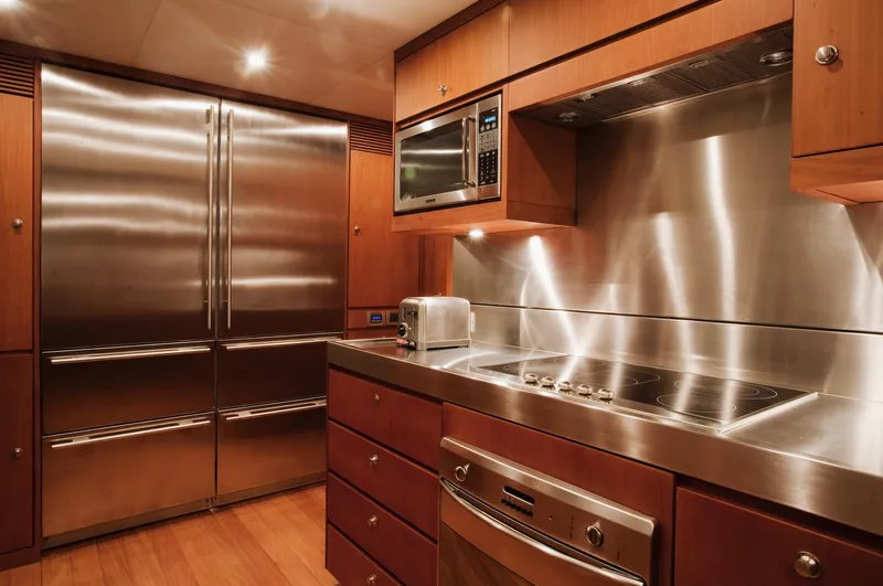 Mare Blu Yacht Photos Pics Luxurious kitchen in 2008 Pro Boat Yachts Power Cat 80, featuring stainless steel appliances and wood cabinetry.