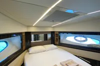 Luxurious bedroom interior of 2015 Pershing 70 yacht with modern design and elegant bedding.