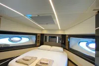 Luxurious bedroom interior of a 2015 Pershing 70 yacht with modern design and elegant lighting.