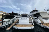 Luxury Pershing 70 yacht from 2015 docked among other boats, showcasing sleek design.