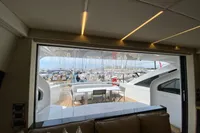 Interior view of 2015 Pershing 70 yacht, showcasing luxurious seating and marina backdrop.