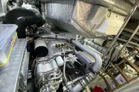 Engine room of a 2015 Pershing 70 yacht, showcasing complex machinery and components.