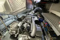 Engine room of a 2015 Pershing 70 yacht, showcasing complex machinery and components.