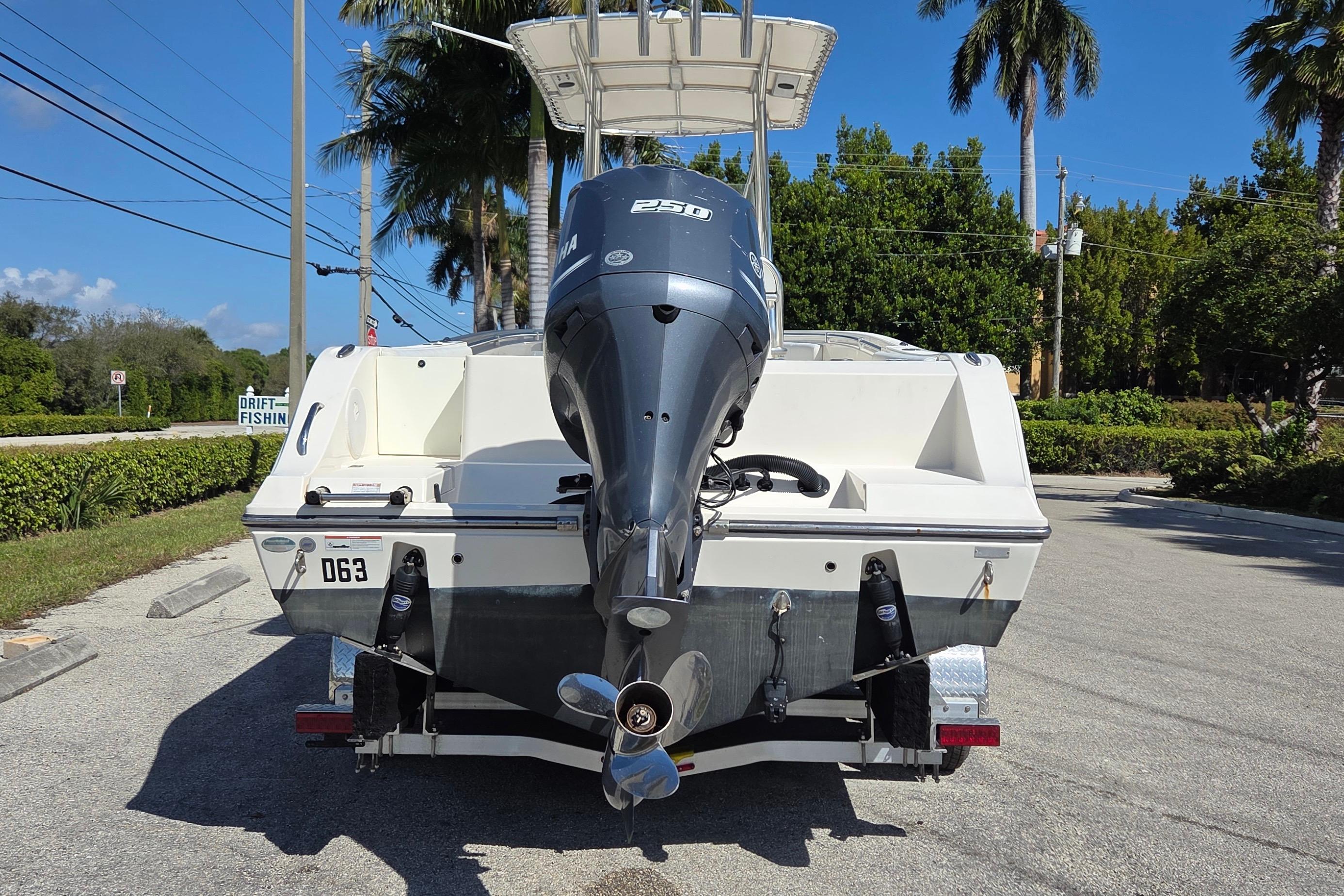 2020 Cobia 237 Center Console boat with Yamaha engine on trailer, parked roadside.
