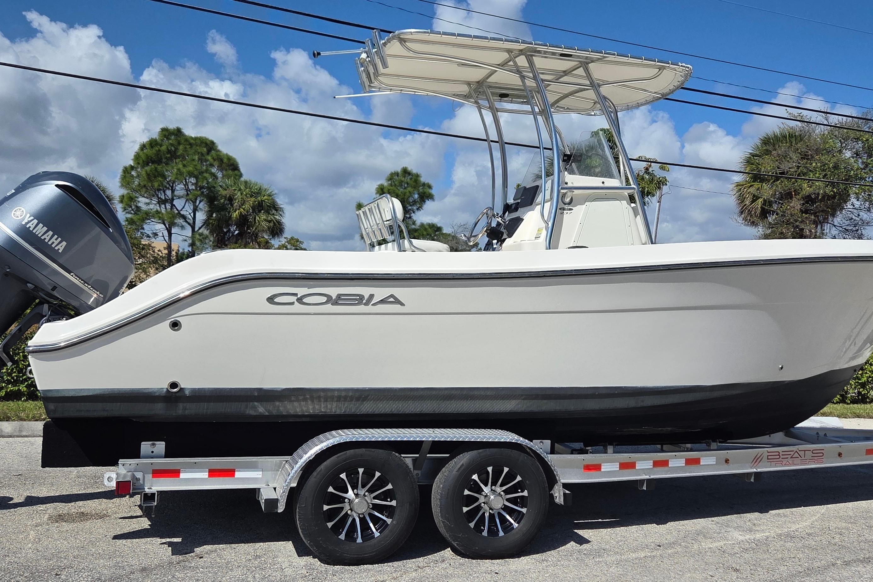 2020 Cobia 237 Center Console boat on trailer with Yamaha engine, under blue sky.