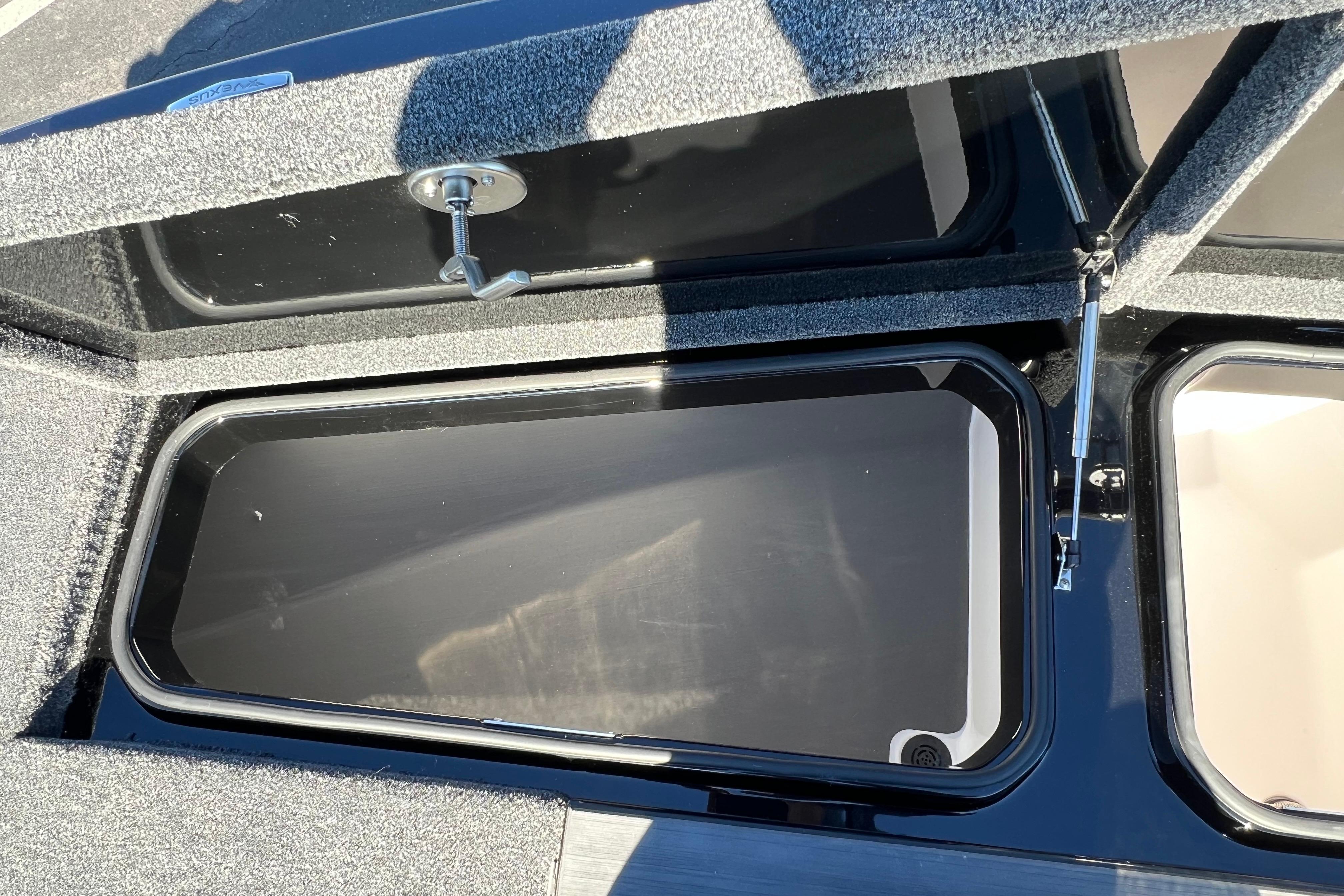 2026 Vexus DVX20S boat storage compartment with open lid and carpeted interior.