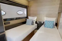 Interior of 2015 Pershing 70 yacht with twin beds and modern decor.