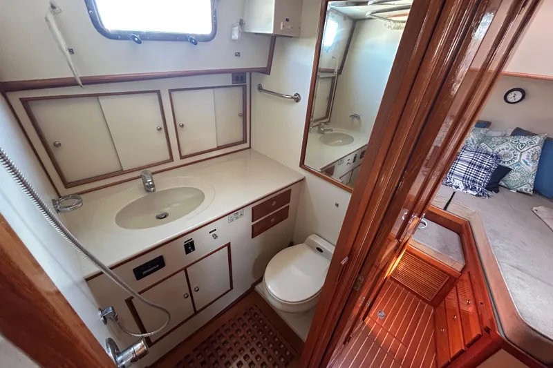 Pearl Yacht Photos Pics Bathroom interior of 1999 Eastbay 38 yacht with sink, toilet, and wooden accents.