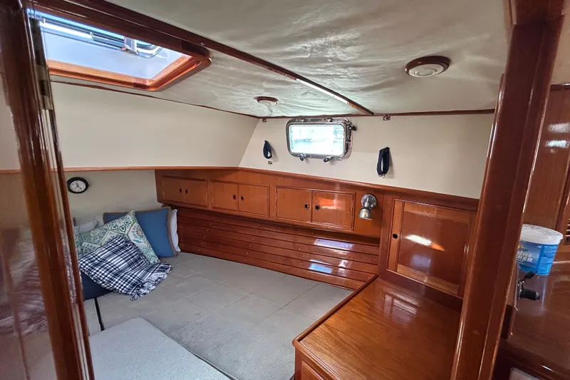 Pearl Yacht Photos Pics Cozy cabin interior of 1999 Eastbay 38 yacht with wooden furnishings and porthole window.
