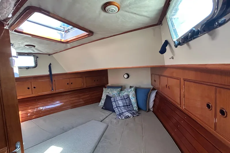 Pearl Yacht Photos Pics Cozy cabin interior of 1999 Eastbay 38 boat with wooden finish and cushions.