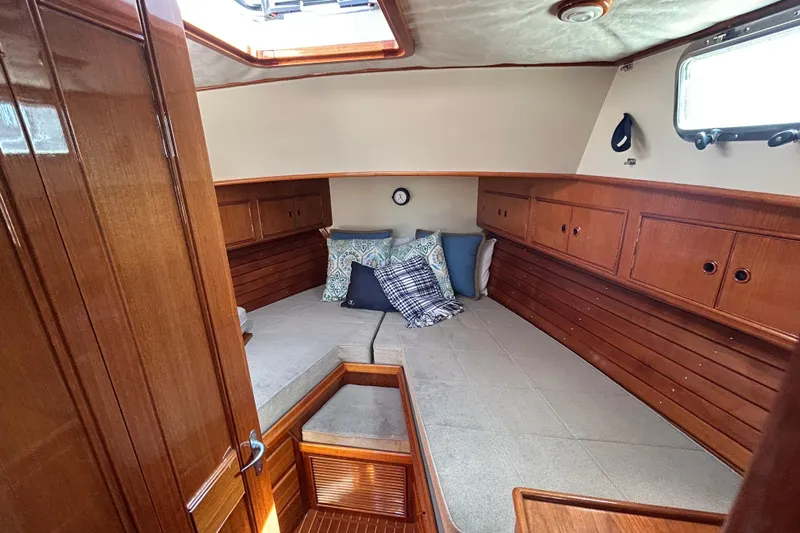 Pearl Yacht Photos Pics 1999 Eastbay 38 yacht cabin with wooden interior and cozy bedding.