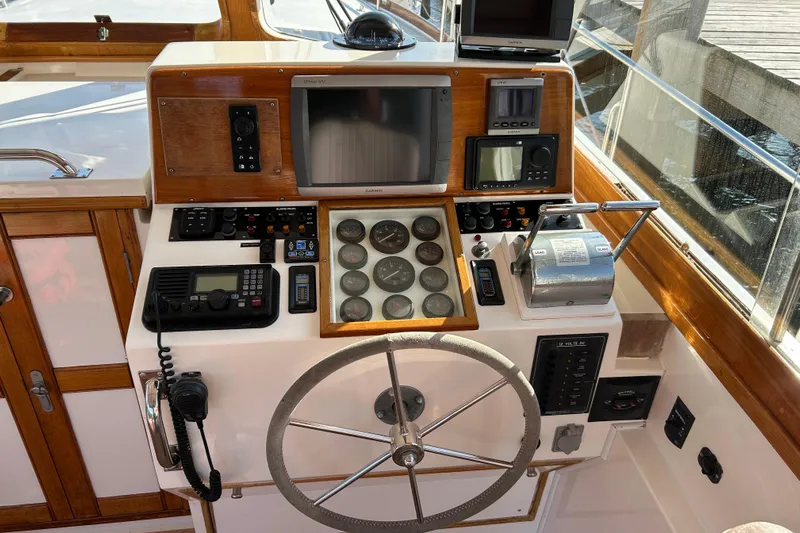 Pearl Yacht Photos Pics Control panel of a 1999 Eastbay 38 boat with navigation instruments and steering wheel.