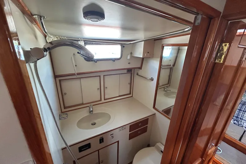 Pearl Yacht Photos Pics Luxurious 1999 Eastbay 38 yacht bathroom with wooden accents and modern fixtures.