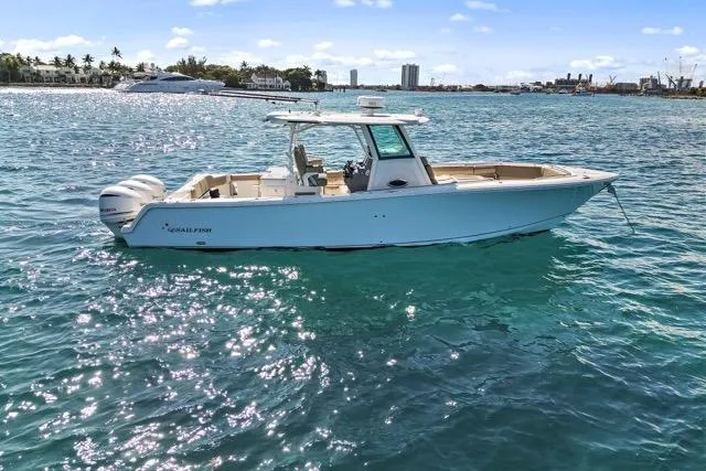 Odd Job Yacht Photos Pics 2019 Sailfish 360 CC boat on clear blue water, sunny day, coastal background.
