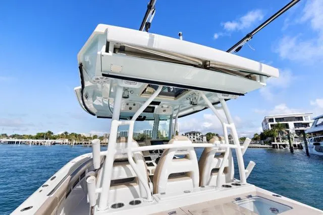 Odd Job Yacht Photos Pics 2019 Sailfish 360 CC boat on water, showcasing helm and seating area under clear blue sky.