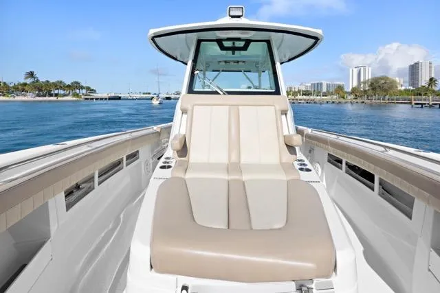 Odd Job Yacht Photos Pics 2019 Sailfish 360 CC boat with beige seating, cruising on a sunny day near a city skyline.