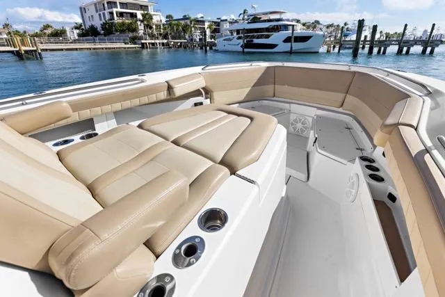Odd Job Yacht Photos Pics 2019 Sailfish 360 CC boat interior with beige seating, cup holders, and waterfront view.