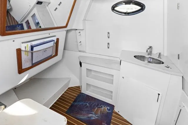 Odd Job Yacht Photos Pics 2019 Sailfish 360 CC boat interior with sink, storage, and wooden flooring.
