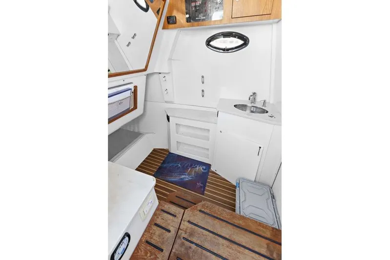 Odd Job Yacht Photos Pics 2019 Sailfish 360 CC cabin interior with sink, storage, and wooden flooring.
