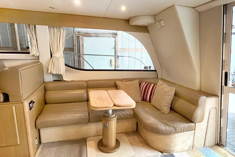 Lucky Stars Yacht Photos Pics Interior of 2002 Bayliner 3788 Convertible Sedan with beige seating and wooden table.