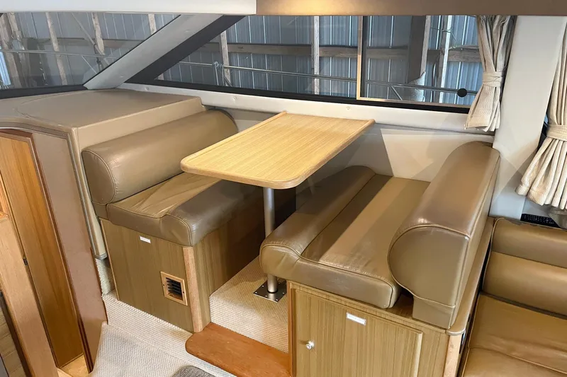Lucky Stars Yacht Photos Pics Interior of 2002 Bayliner 3788 Convertible Sedan with leather seating and wooden table.