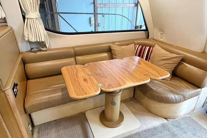 Lucky Stars Yacht Photos Pics 2002 Bayliner 3788 Convertible Sedan interior with cozy seating and wooden table.