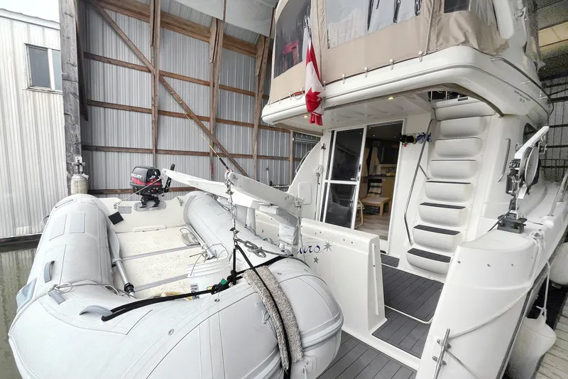 Lucky Stars Yacht Photos Pics 2002 Bayliner 3788 Convertible Sedan with inflatable dinghy in a covered dock.