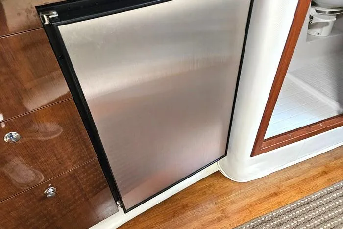  Yacht Photos Pics 2014 Four Winns V375 yacht interior with stainless steel fridge and wooden flooring.