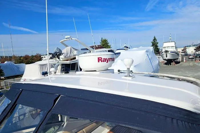  Yacht Photos Pics 2014 Four Winns V375 boat with Raymarine radar, docked in a marina under clear blue skies.