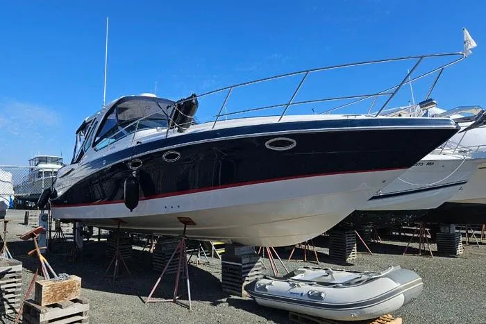  Yacht Photos Pics 2014 Four Winns V375 boat on stands, blue hull, clear sky background.