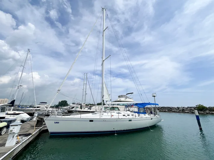 Lali Yacht Photos Pics 1994 Beneteau Oceanis 510 CU sailboat docked in a marina under a cloudy sky.