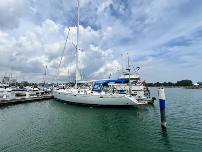 Lali Yacht Photos Pics Sailboat Beneteau Oceanis 510 CU, 1994 model, docked at marina under cloudy sky.
