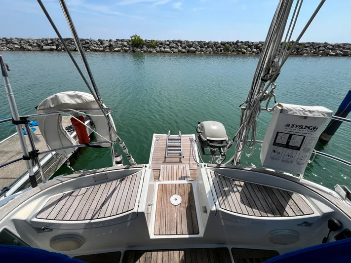 Lali Yacht Photos Pics 1994 Beneteau Oceanis 510 CU sailboat stern view with wooden deck and lifebuoy.