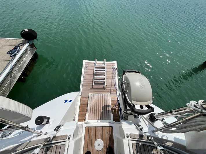 Lali Yacht Photos Pics 1994 Beneteau Oceanis 510 CU yacht stern with wooden deck and outboard motor.