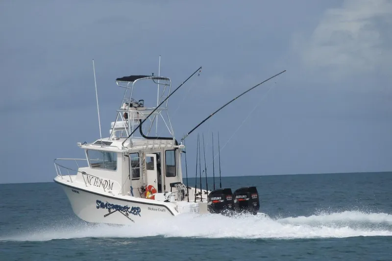  Yacht Photos Pics 2009 McKee Craft 28 boat cruising on the ocean with fishing rods and Suzuki engines.