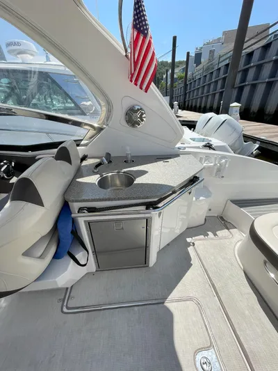 Black Pearl Yacht Photos Pics 2018 Chaparral 337 SSX boat interior with kitchenette and American flag.
