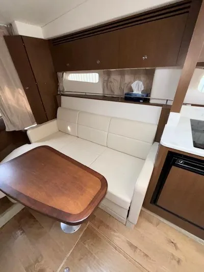  Yacht Photos Pics Interior of 2019 Sea Ray 350 Sundancer Coupe with white sofa and wooden table.