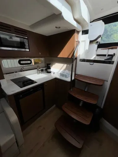  Yacht Photos Pics Interior of 2019 Sea Ray 350 Sundancer Coupe with modern kitchen and wooden stairs.