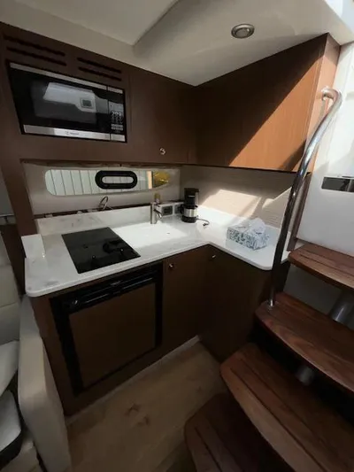  Yacht Photos Pics 2019 Sea Ray 350 Sundancer Coupe kitchen with modern appliances and wooden cabinetry.