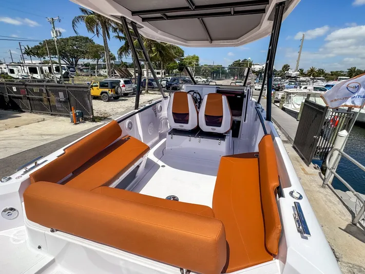  Yacht Photos Pics 2025 Axopar 25 Cross Top boat with orange seating, docked at a marina.