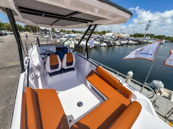  Yacht Photos Pics 2025 Axopar 25 Cross Top boat with orange seating, docked at a marina.