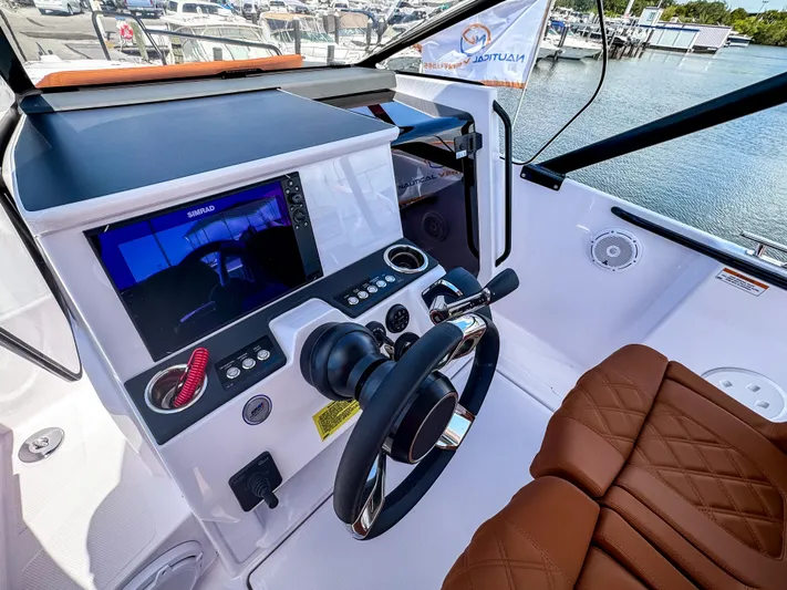  Yacht Photos Pics 2025 Axopar 25 Cross Top boat cockpit with modern controls and brown leather seating.