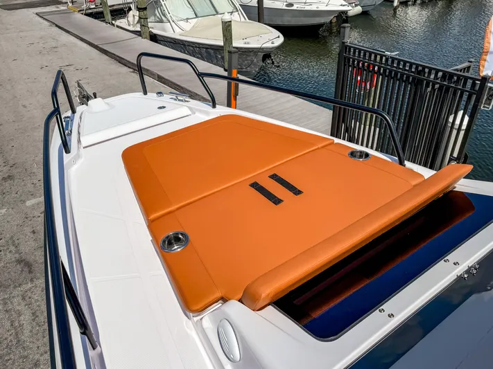  Yacht Photos Pics 2025 Axopar 25 Cross Top boat with orange sunbed, docked at marina.