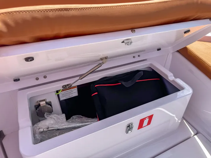  Yacht Photos Pics Open storage compartment on 2025 Axopar 25 Cross Top boat with safety equipment.