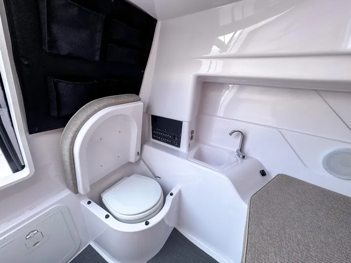  Yacht Photos Pics 2025 Axopar 25 Cross Top boat interior with compact toilet and sink.