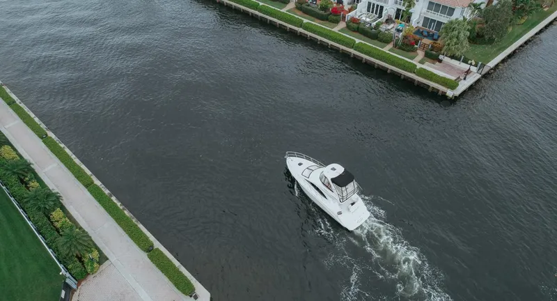  Yacht Photos Pics Aerial view of 2010 Sea Ray 390 Sedan Bridge cruising near waterfront homes.