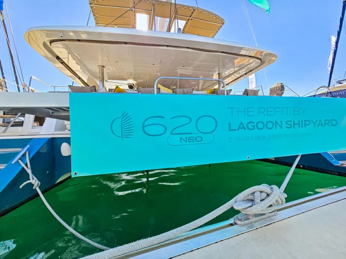 Firefly Yacht Photos Pics Lagoon 620 NEO catamaran, 2012 model, displayed at a marina with branding banner.