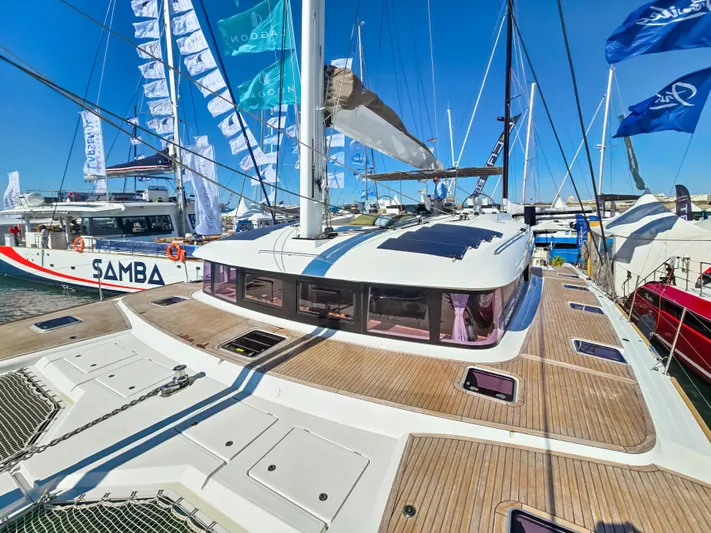 Firefly Yacht Photos Pics Luxurious 2012 Lagoon 620 NEO catamaran docked at a marina, showcasing sleek design.